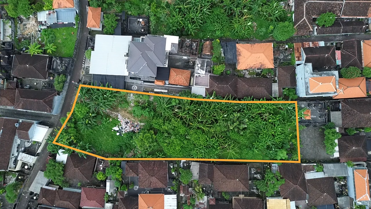 Terrain vierge du projet phase 13, entouré en orange, avec des maisons traditionelles autour à Bali